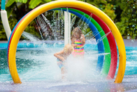 As crianças do círculo do arco-íris do parque do pulverizador de água molham o parque colorido do respingo da água do campo de jogos